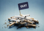 Quit or stop smoking concept pile of damaged cigarettes with sign