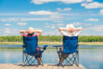 man and woman relaxing on the dock of a lake