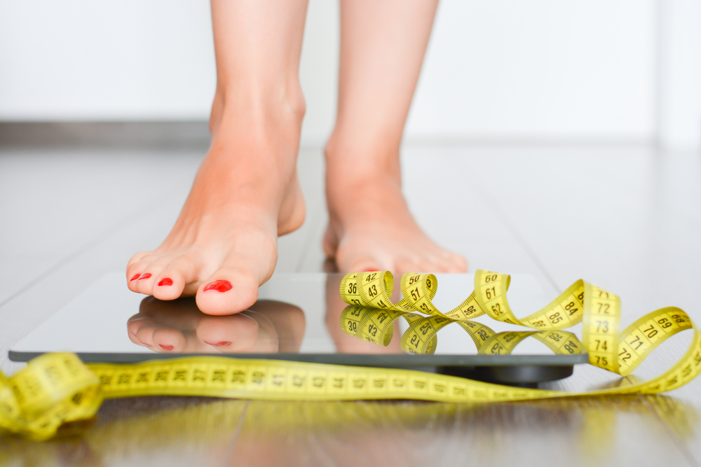 woman's feet standing on weight scale