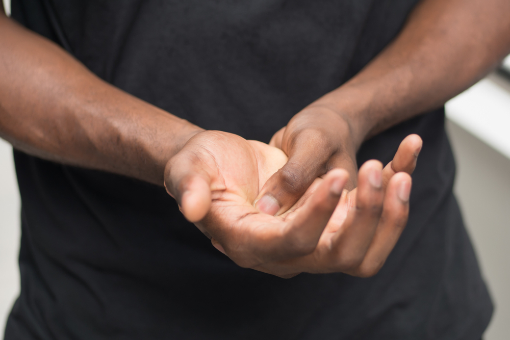 Man with hand pain caused by diabetes