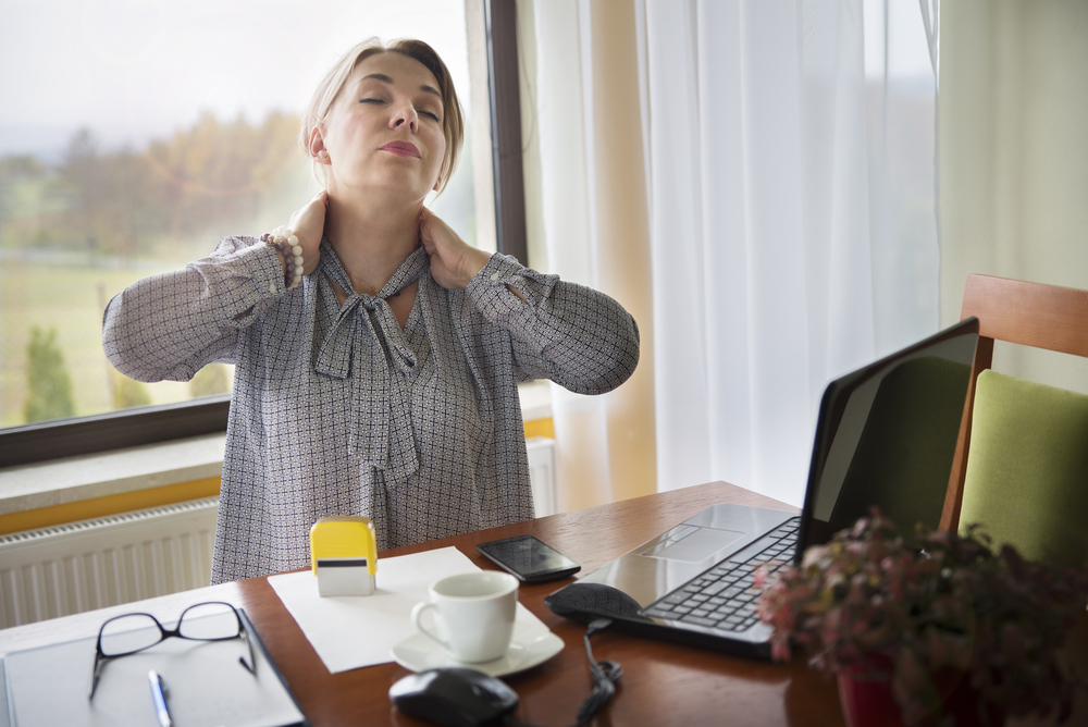woman suffering from pain in neck working from home