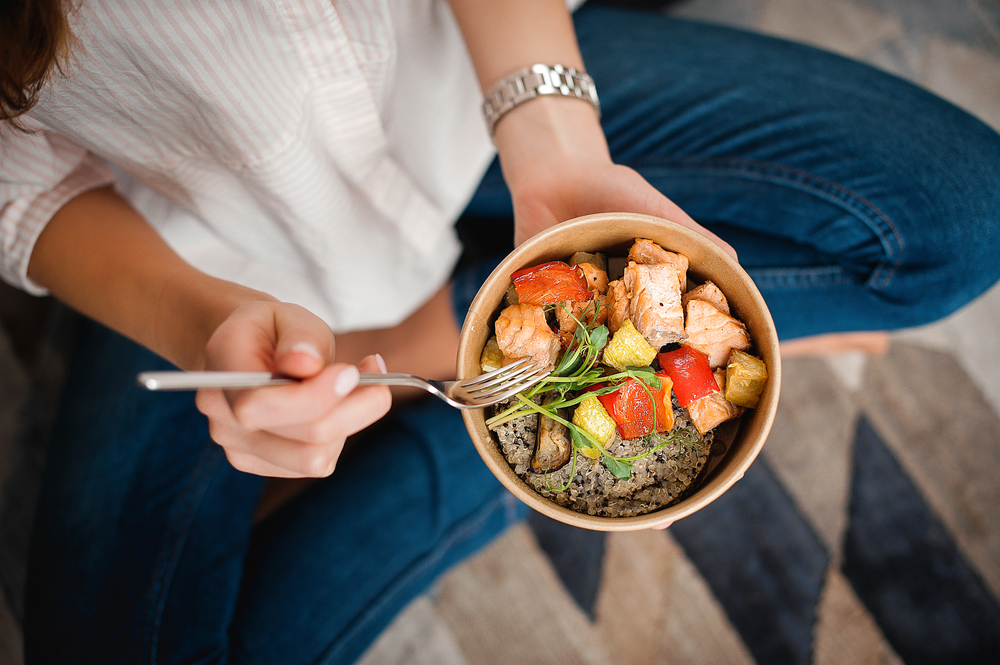 Woman holding bowl of nutritious food