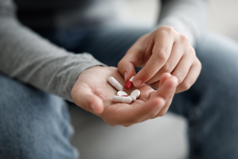 Man holding pills in hand.