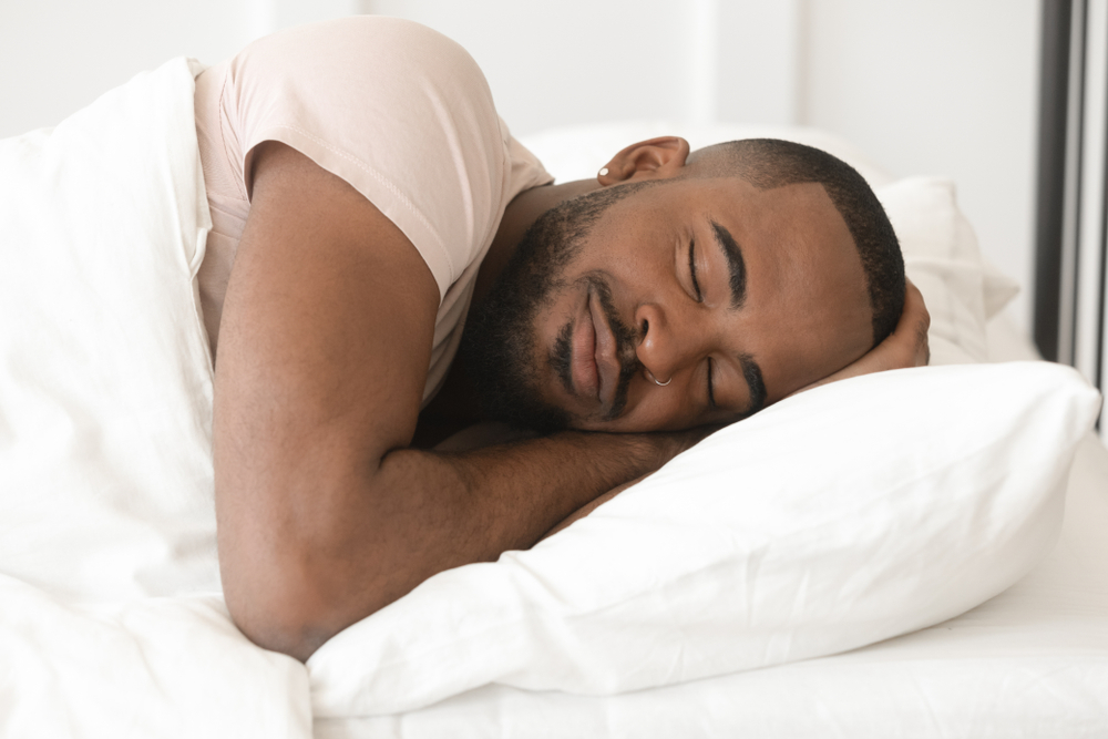 well-rested african american man still in bed sleeping