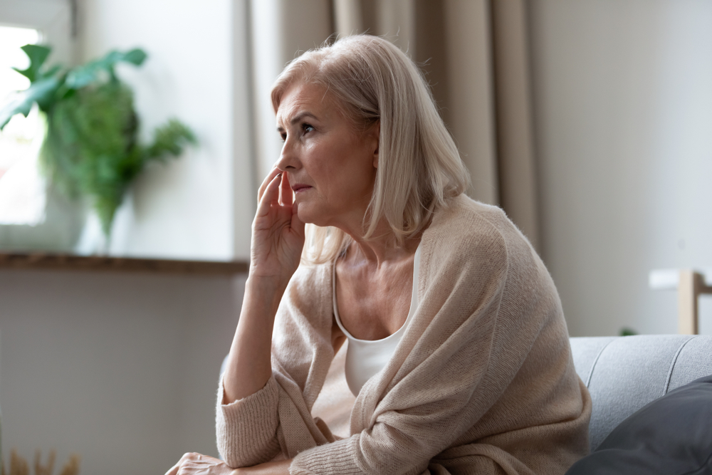 woman sitting on couch looking out window