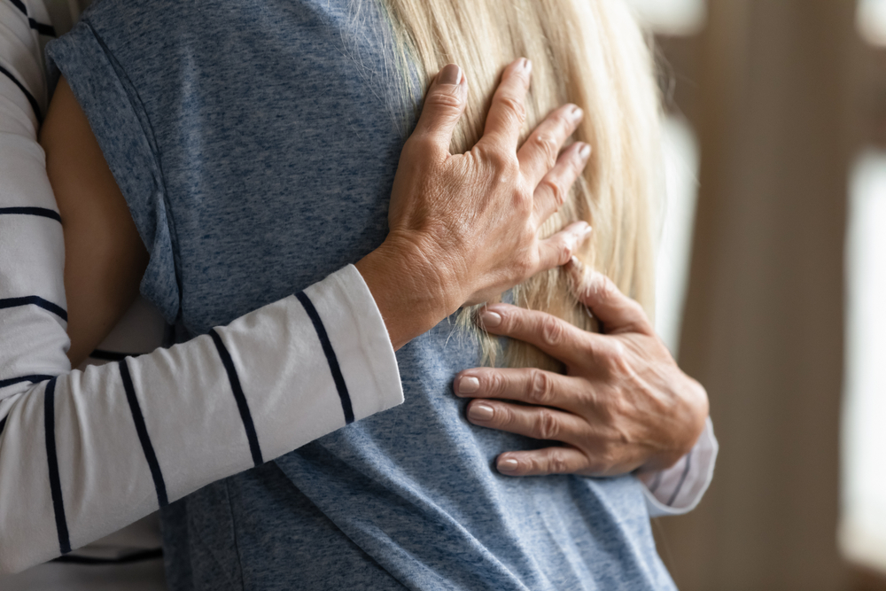 two women hugging in support