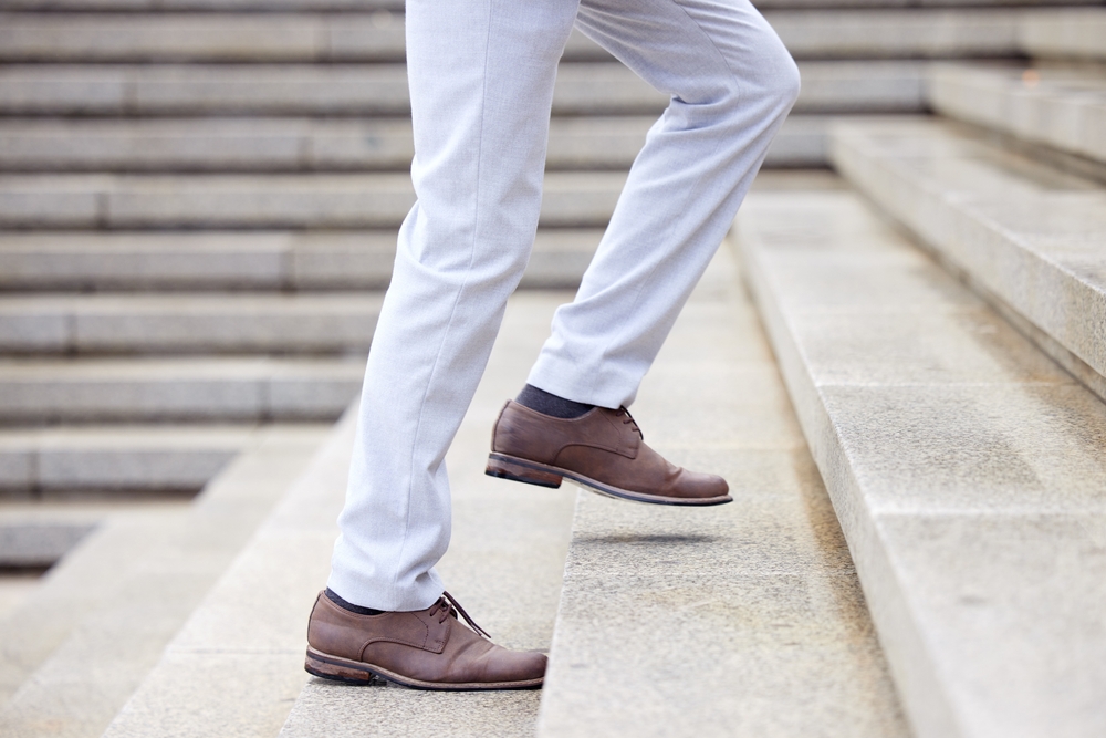 Businessman, stairs and success taking steps toward progress, development and achievement for industry.